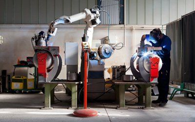 Industrial Jobs — Man and Robotic Machine Working Together in Cullman, AL Industrial Jobs — Man and Robotic Machine Working Together in Cullman, AL