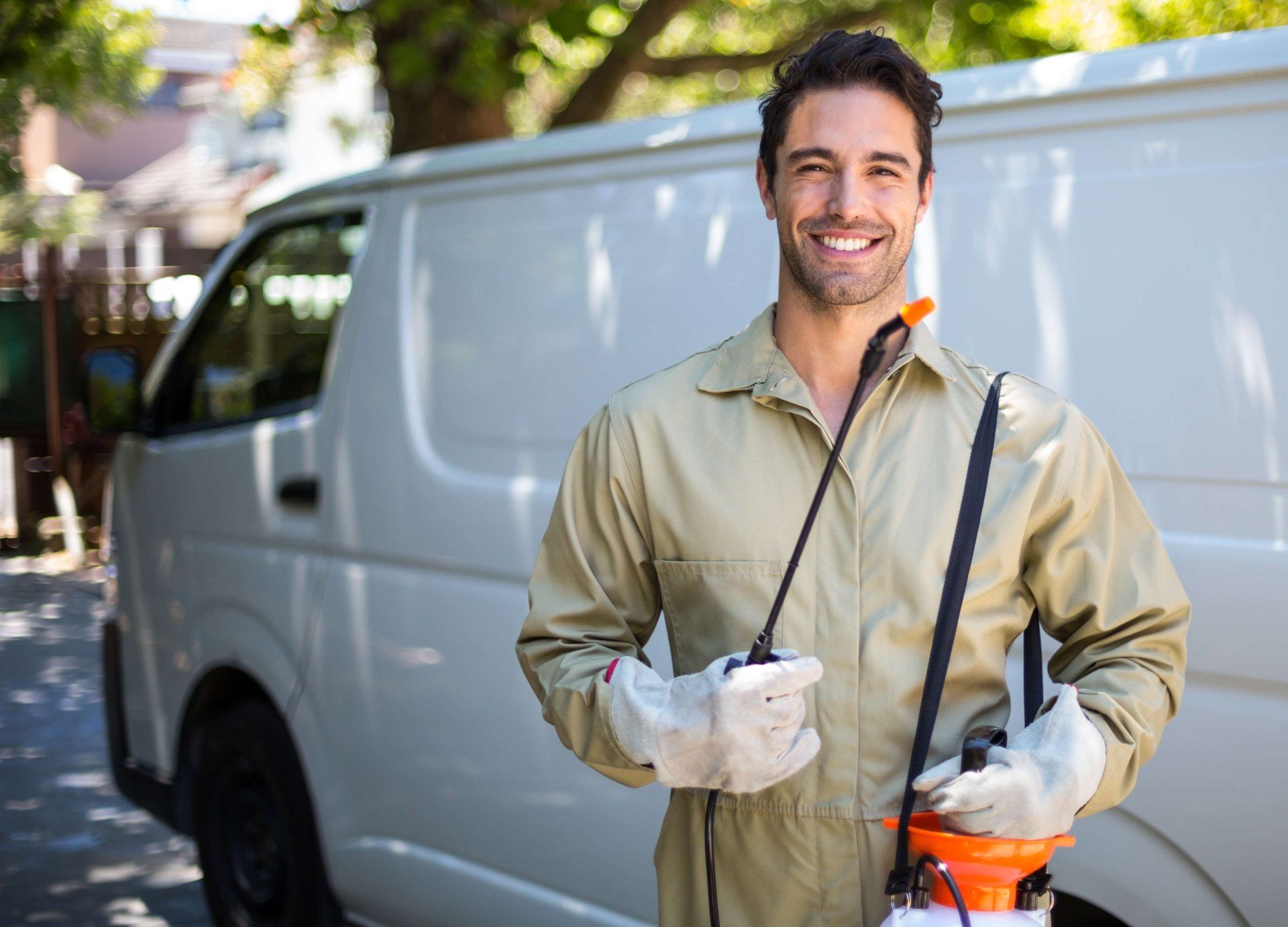 A man is holding a sprayer in front of a van.