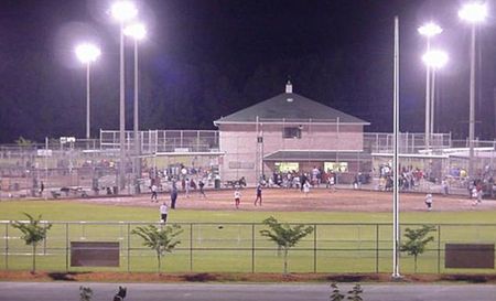 Commercial & Industrial Landscape Design — Meridian, MS — Engineering Plus, Inc. Baseball field at night, lit by bright lights, with players on the field and a building in the background.