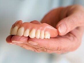 Dentist holding denture - Dentist in Mansfield, OH