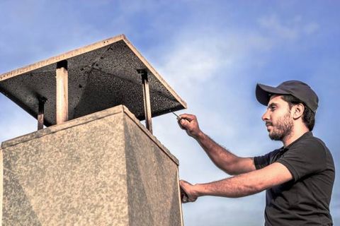 Man Is Installing A Typical Exhaust — Huntington Beach, CA — Amm Air Conditioning & Heating Man Is Installing A Typical Exhaust — Huntington Beach, CA — Amm Air Conditioning & Heating