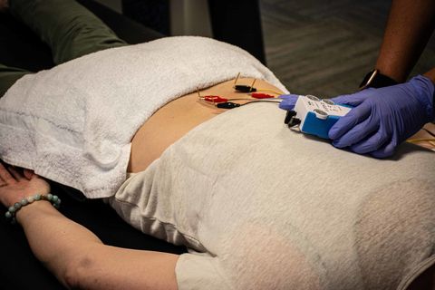 A woman is laying on a table with a towel on her stomach