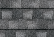 Dark gray asphalt roof shingles in a staggered pattern.