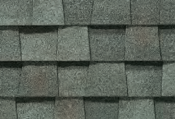 Close-up of gray asphalt roof shingles, staggered in rows.