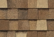 Close-up of brown asphalt roof shingles with varying shades, providing texture and dimension.