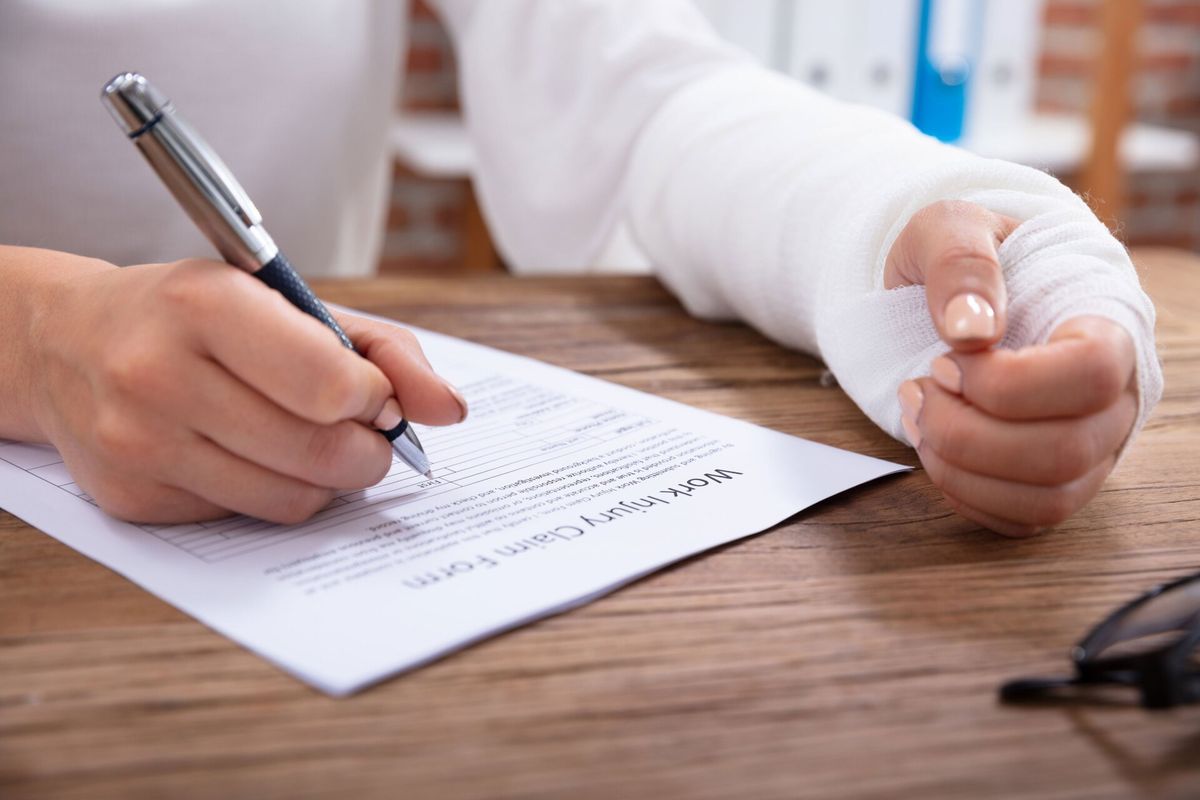 Injured Woman Filling Work Injury Claim Form — North Charleston, SC — Cartee Law Firm Injured Woman Filling Work Injury Claim Form — North Charleston, SC — Cartee Law Firm