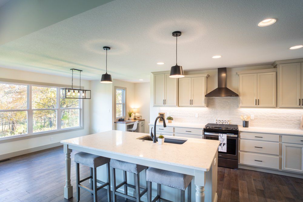 New Kitchen With Barstools & Island by Hansman Custom Homes in Mid-Missouri