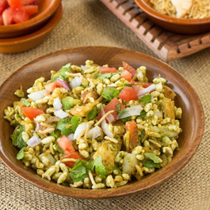 A bowl of food with tomatoes and onions on a table