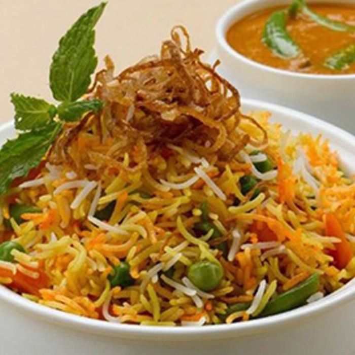 A bowl of rice and vegetables next to a bowl of soup.