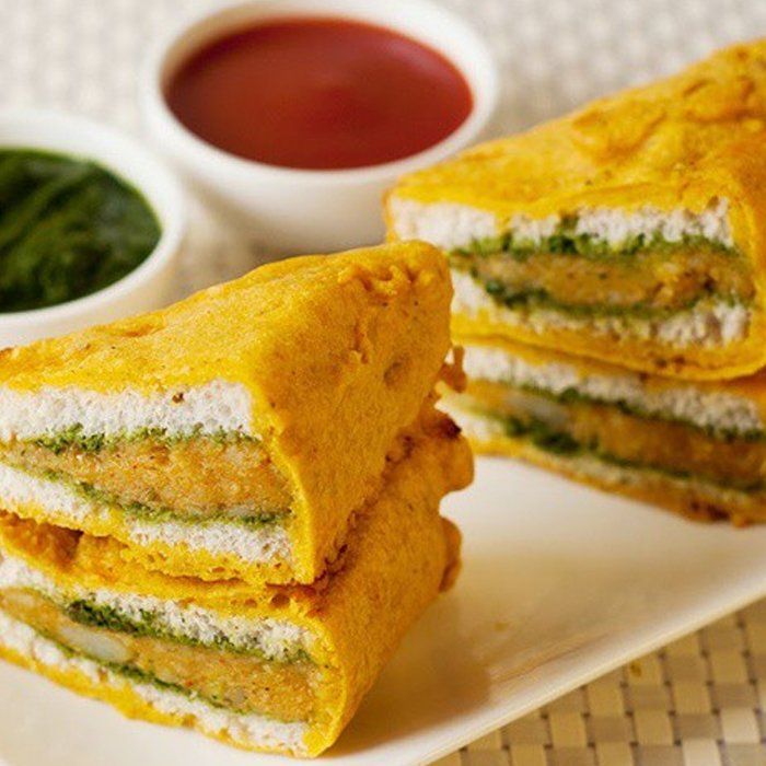 Three sandwiches are stacked on top of each other on a white plate
