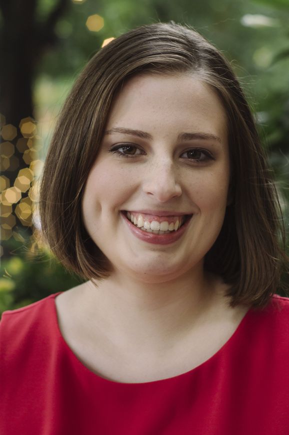 A woman in a red dress is smiling for the camera.