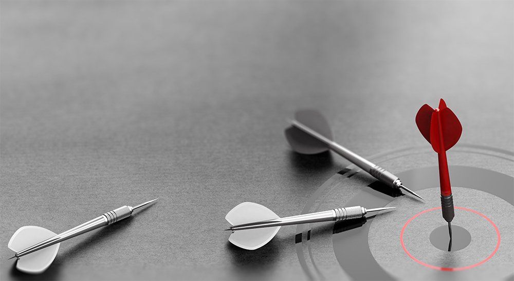 3D illustration of a red dart reaching the center of a target over grey background and other one failed to achieve goal. Concept of business or corporate success.