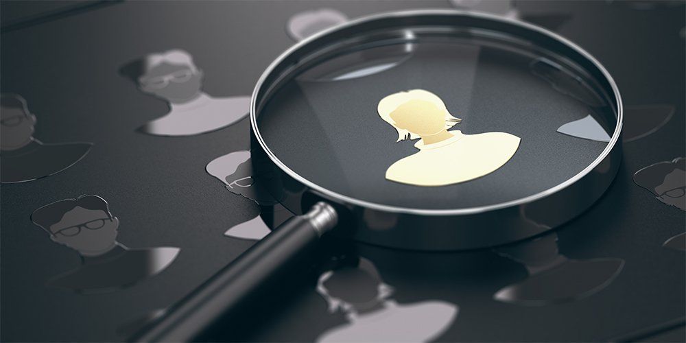 test Black background with silhouettes of men and women with focus on a golden talent and a magnifying glass. Staffing concept.
