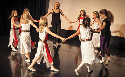 group on dancers on stage in a ring hand in hand