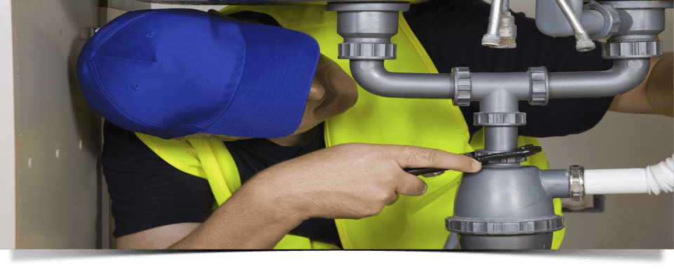 plumber fixing the pipes under a sink