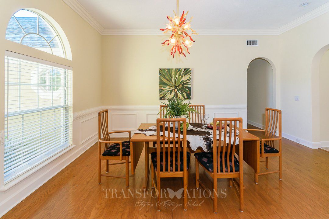 A dining room with a table and chairs and a chandelier.