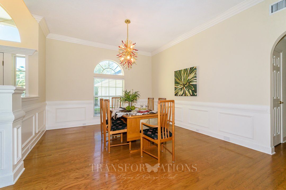 A dining room with a table and chairs and a chandelier.