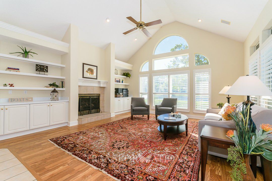 A living room with a fireplace , couch , chairs and a rug.