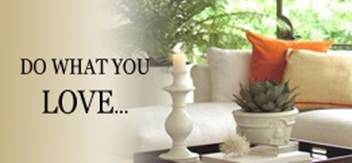 A living room with a couch , pillows , candles and a potted plant.