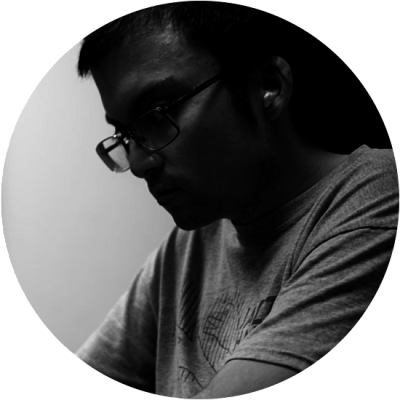 Man wearing glasses, looking down, in a grayscale, round image.