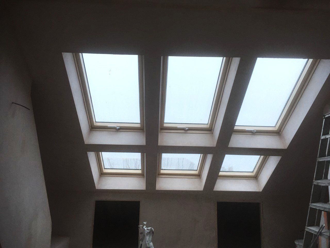 A room with a lot of skylights and a ladder