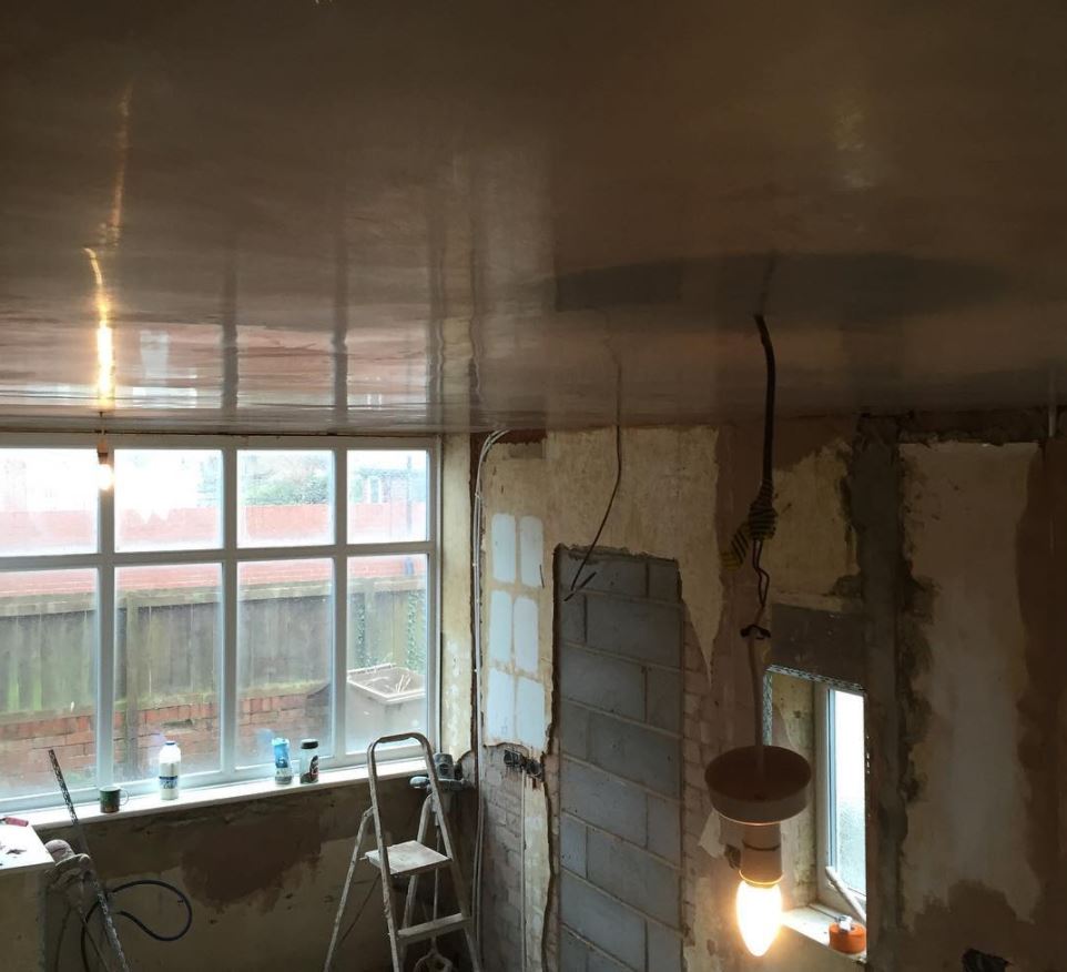 A room with a ladder and a light hanging from the ceiling