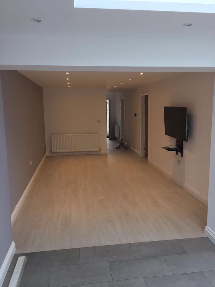 A living room with a flat screen tv mounted on the wall.