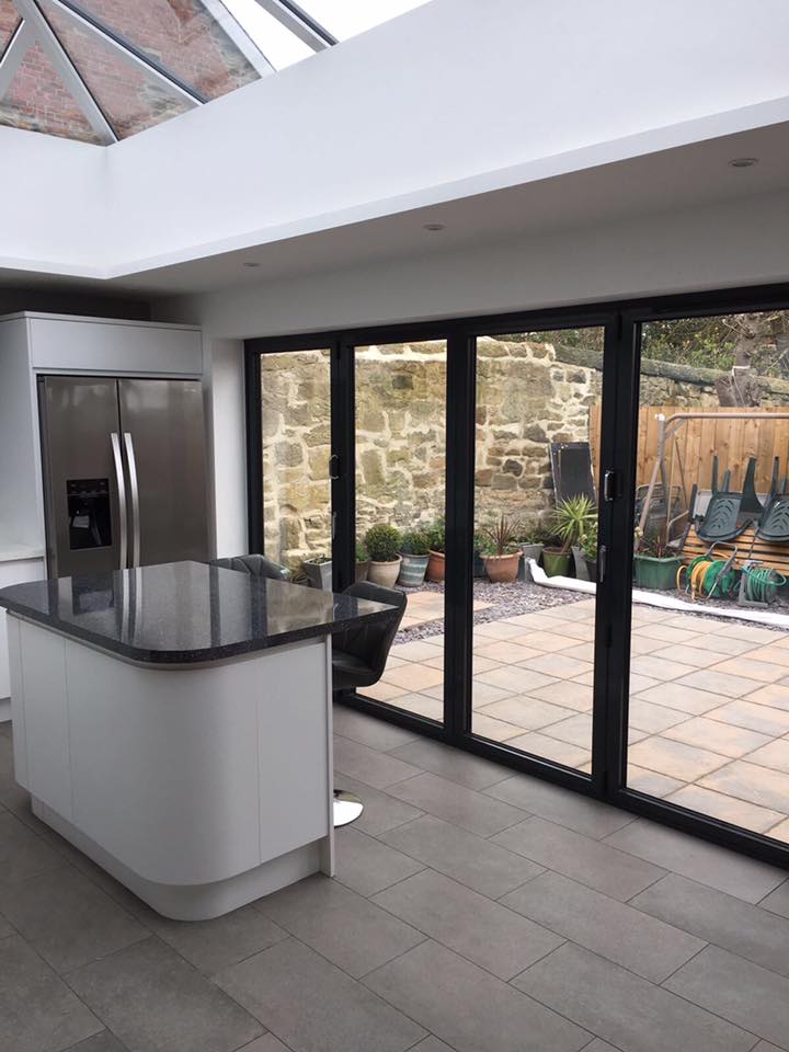 A kitchen with a large island and sliding glass doors leading to a patio.