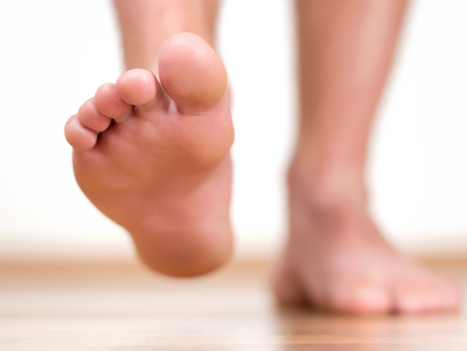 Person with bare feet taking a step forward