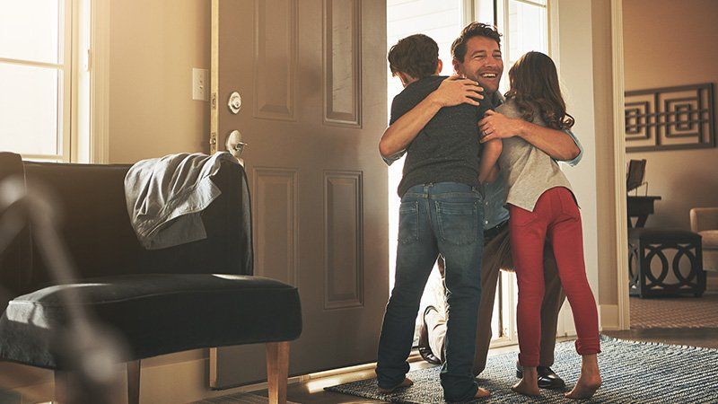 man hugging two kids