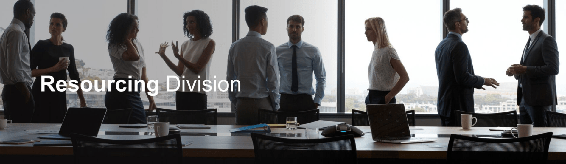 A group of people are standing around a table in a conference room.