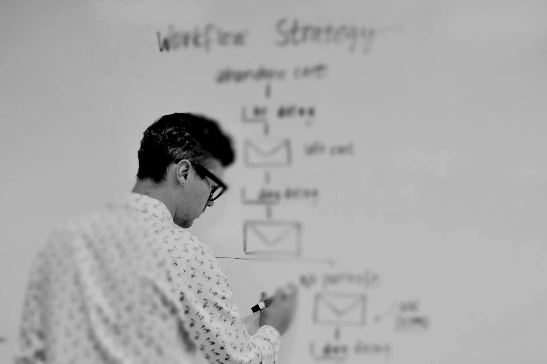 A person in a patterned shirt writing a