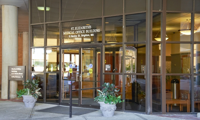 Entrance to St. Elizabeth's Medical Office Building with glass doors and windows, surrounded by potted plants.