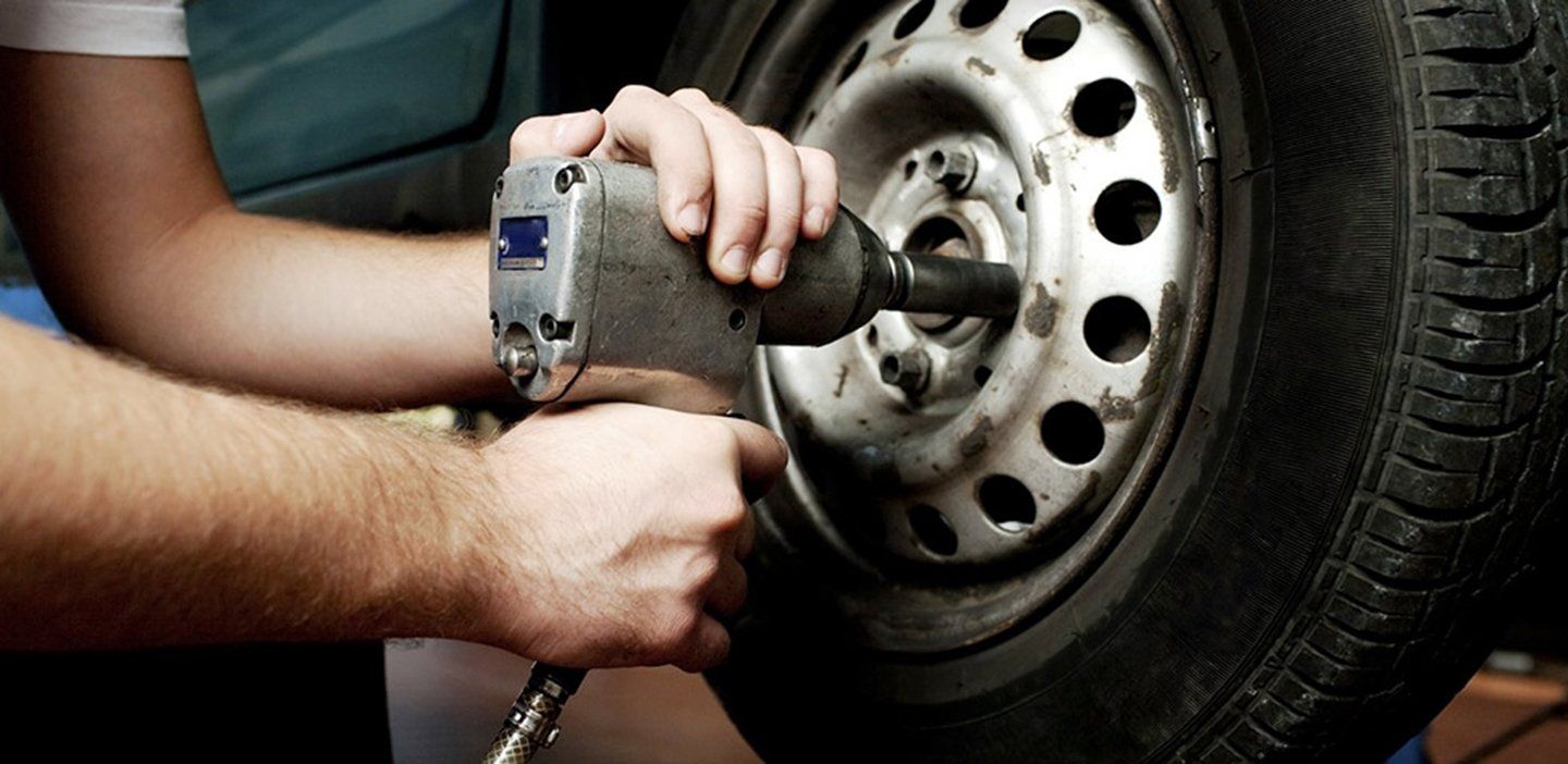meccanico mentre sostituisce una ruota di un'auto
