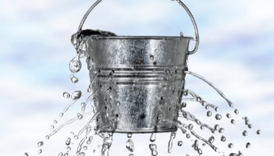 A bucket of water leaking through holes and spilling over.
