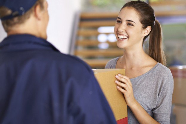 A woman accepting a package from a delivery man.