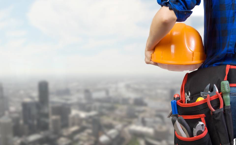 operaio con caschetto e attrezzi da lavoro