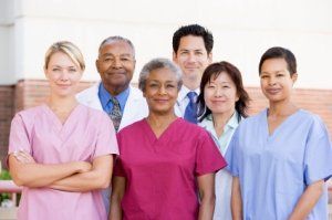 Group of healthcare workers in colorful scrubs standing together and smiling