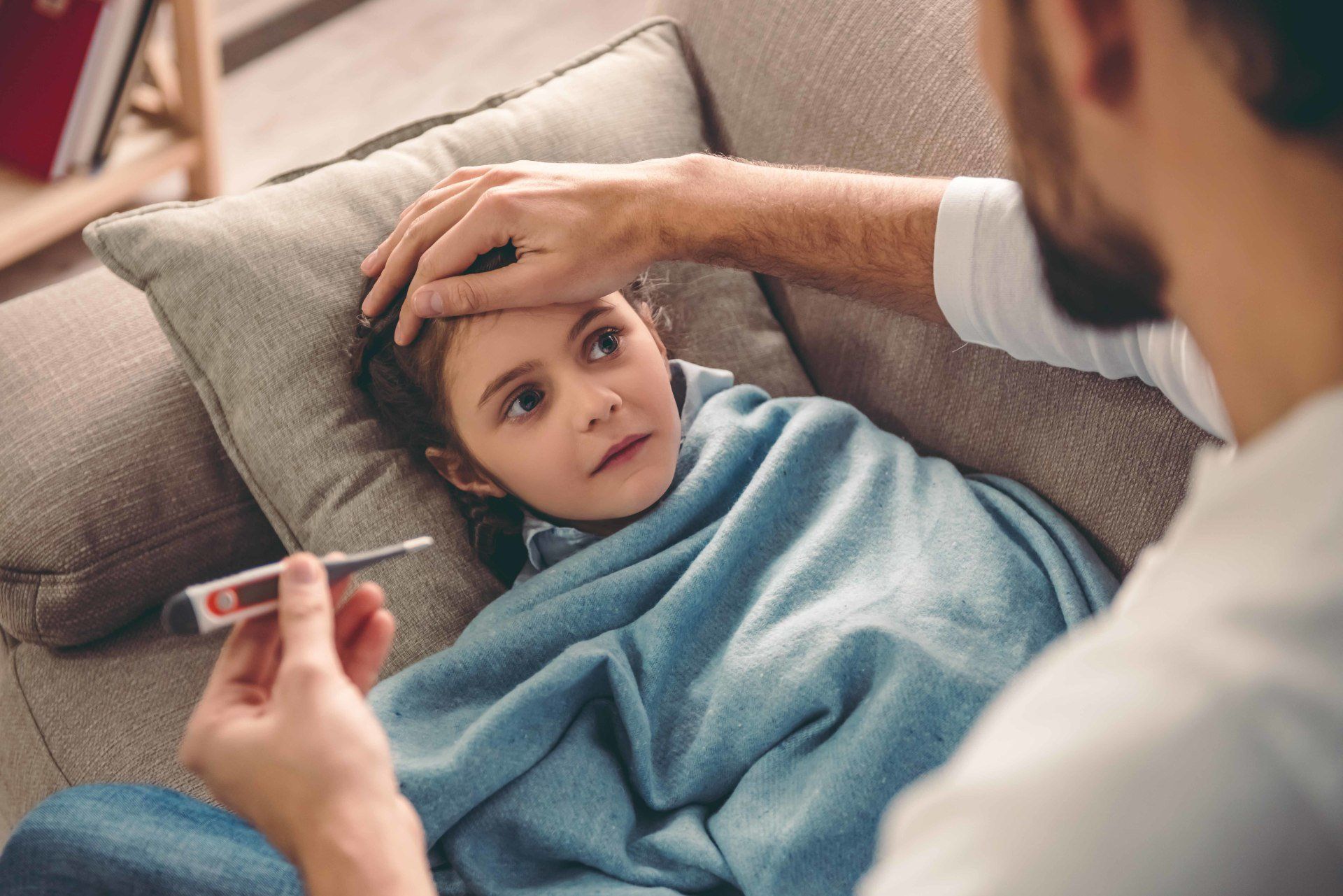 child having their temperature taken by an adult