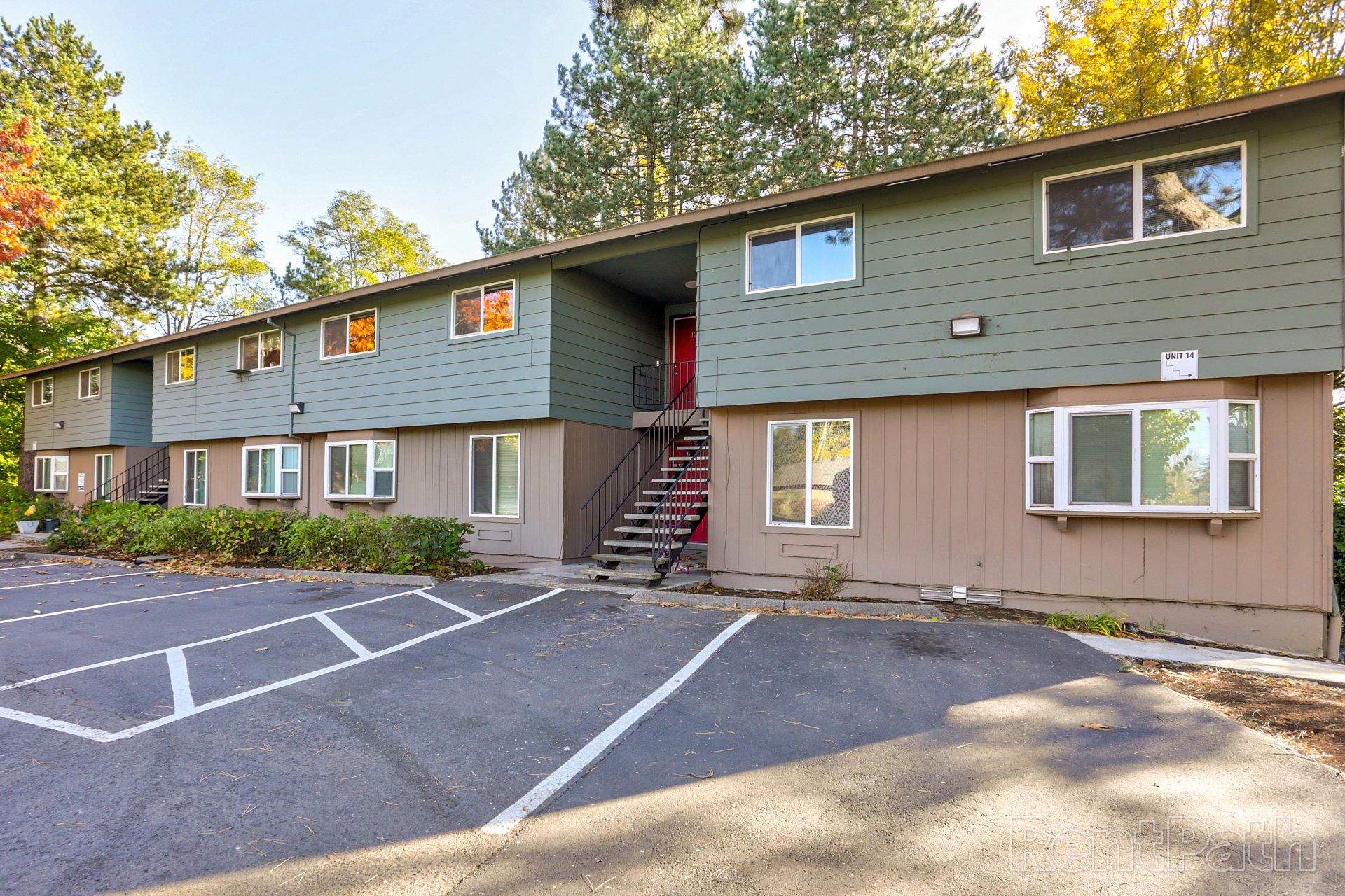 A large apartment building with a parking lot in front of it