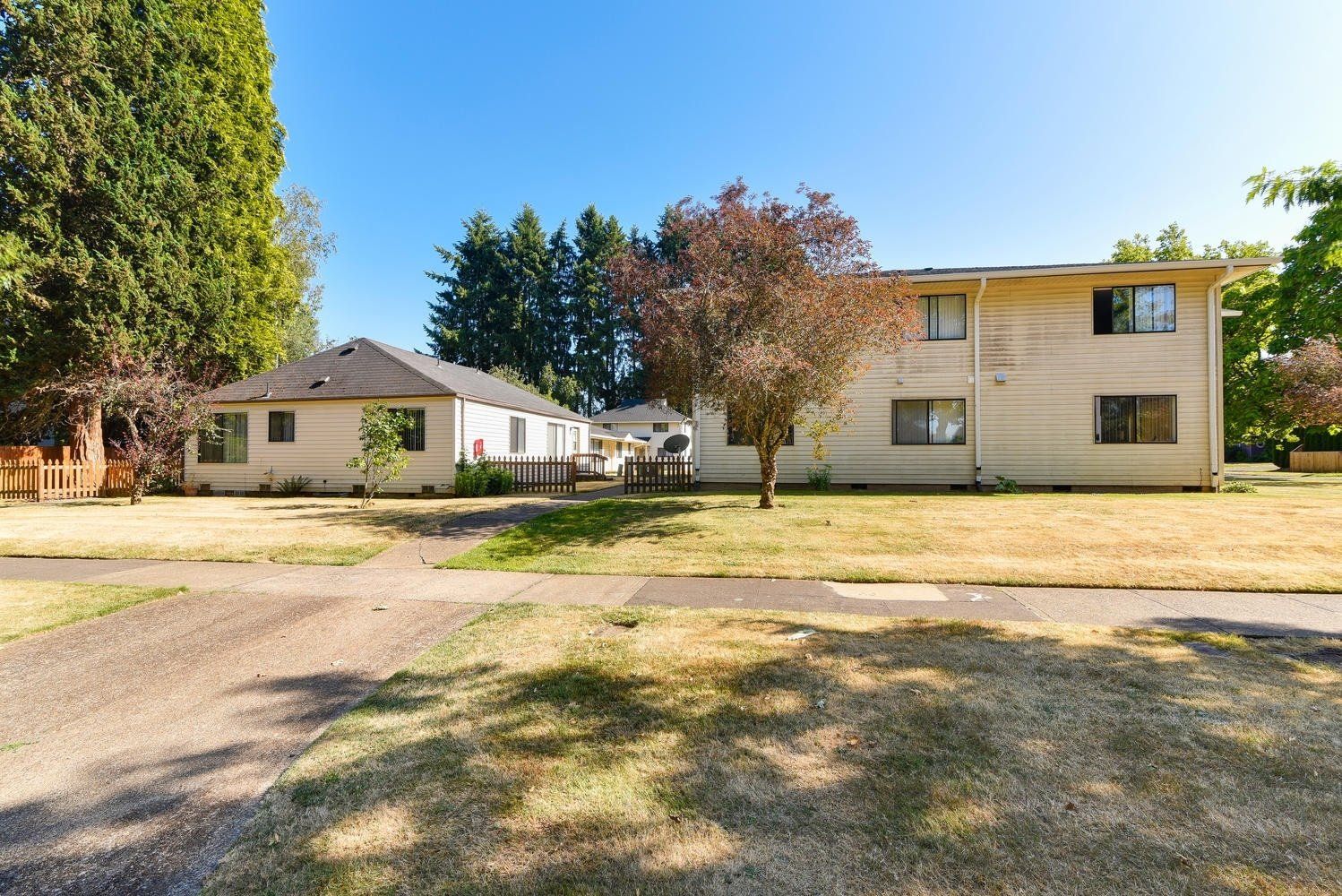 A house with a lot of grass and trees in front of it