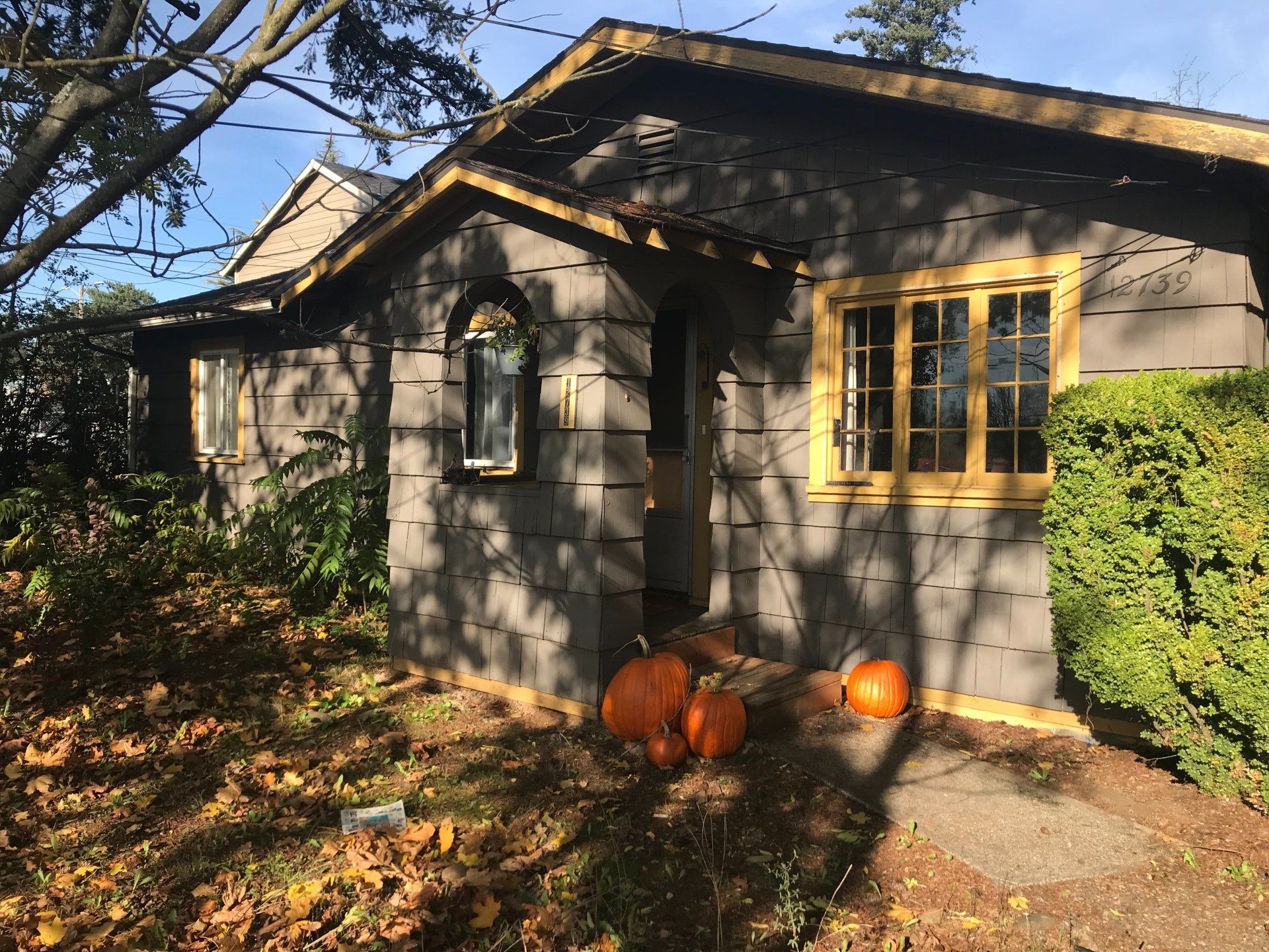 A house with pumpkins in front of it on a sunny day