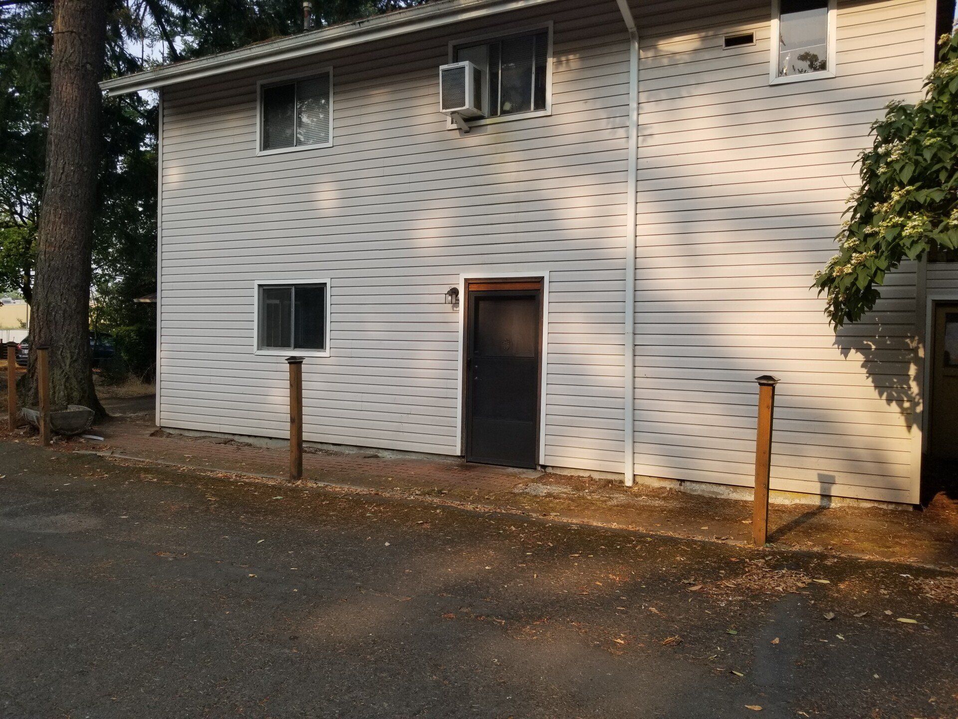 A white house with a black door and a fence in front of it