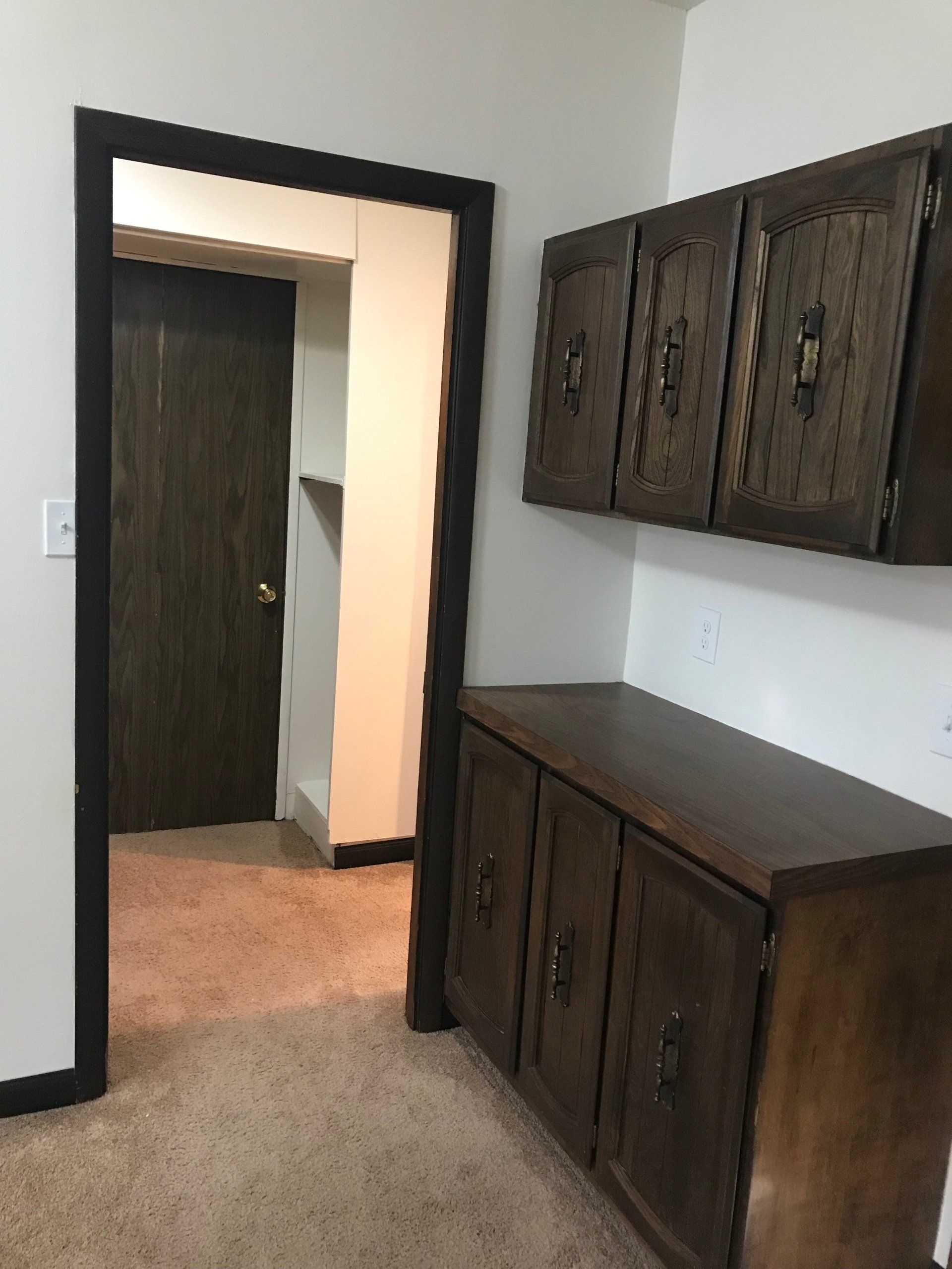 A room with a wooden cabinet and a door
