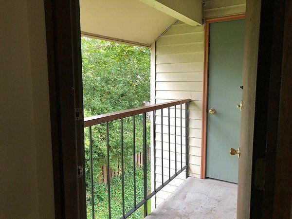 A balcony with a railing and a door in a house.