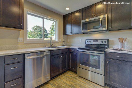 A kitchen with stainless steel appliances and wooden cabinets.