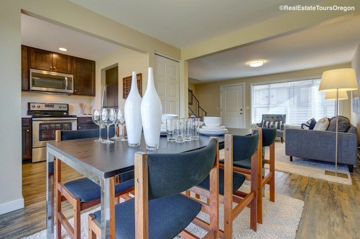 A dining room table with chairs and vases on it