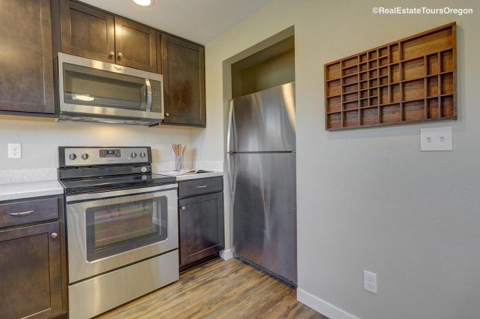 A kitchen with stainless steel appliances and wooden cabinets.