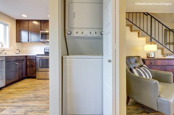 A washer and dryer are in a closet in a kitchen.