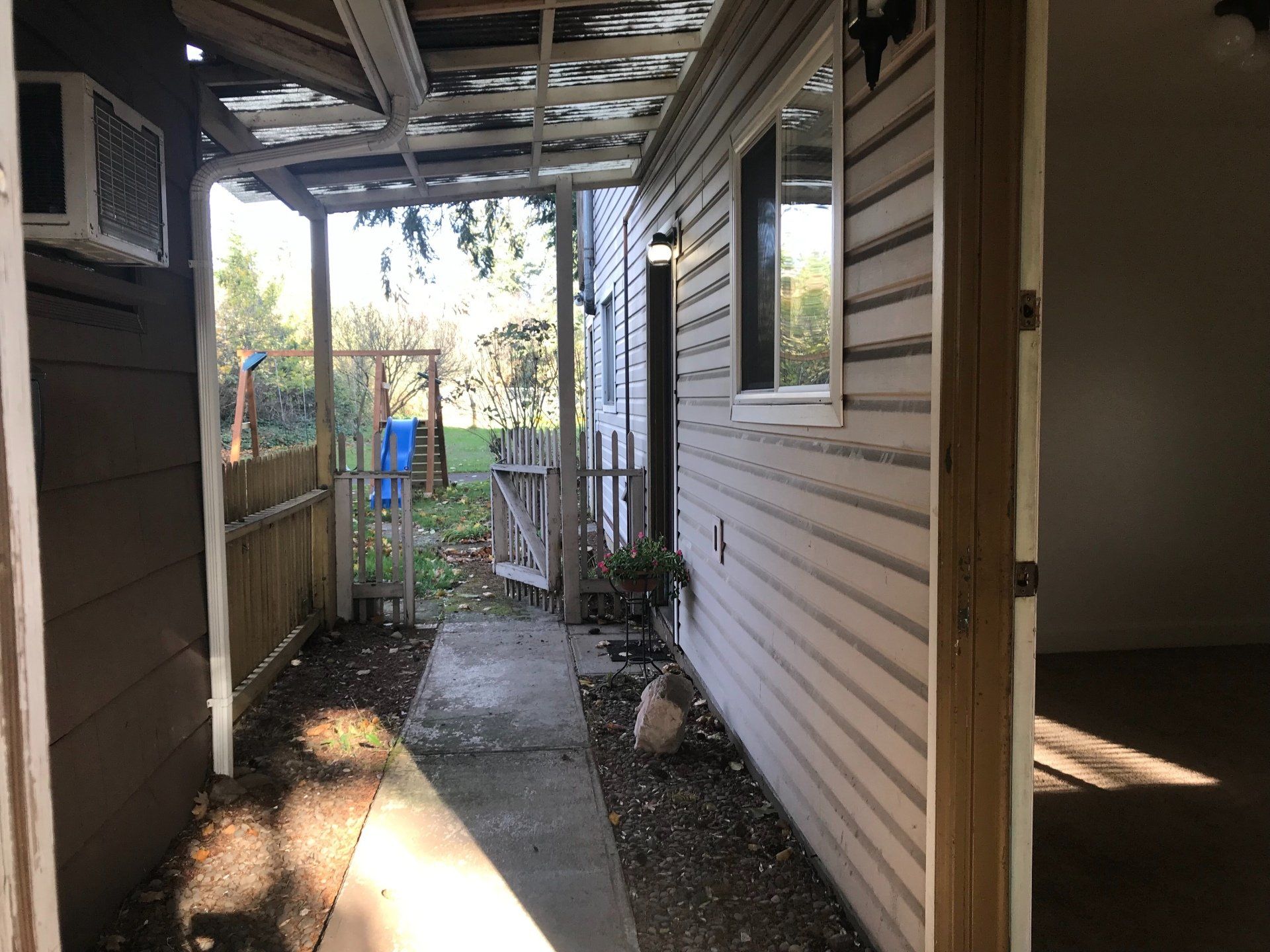 A house with a covered walkway leading to the backyard.